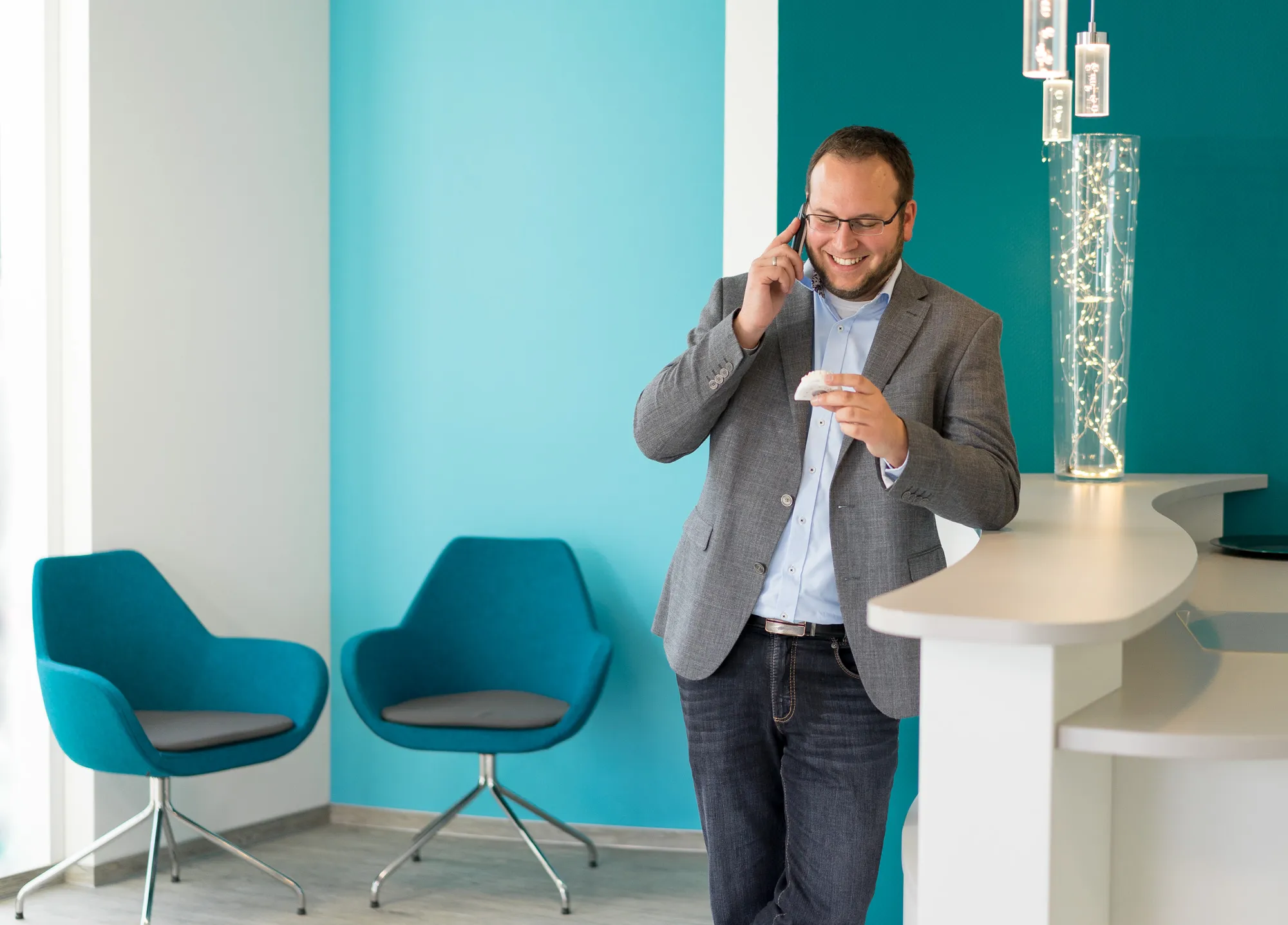 Geschäftsmann im Sakko telefoniert in modernem Büro
